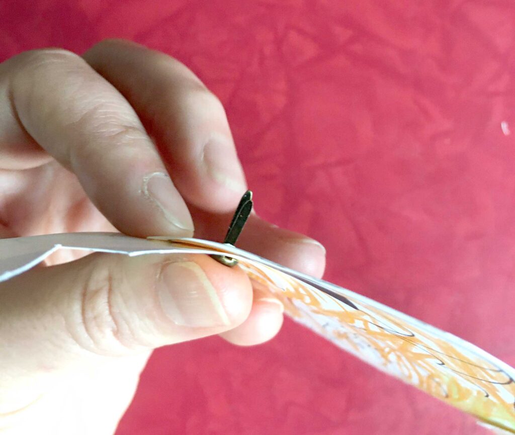 Assembling baby dragon puppet with brad