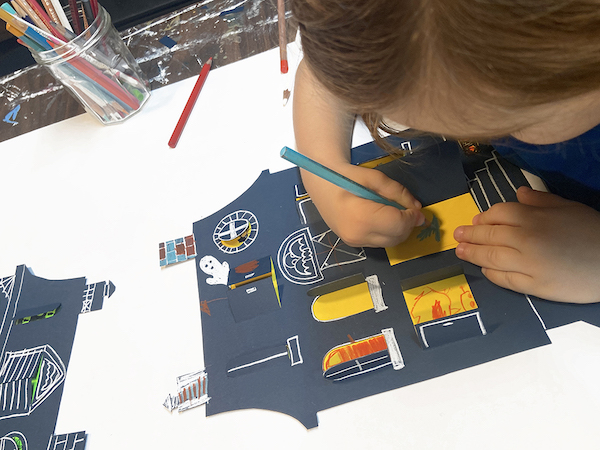 Child drawing on haunted house paper craft